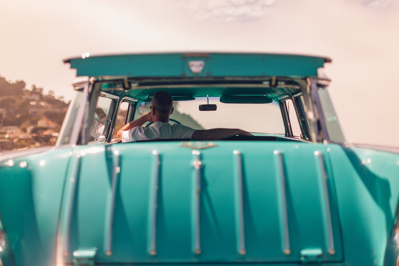 Voiture turquoise sur une route, vue de l'arrière